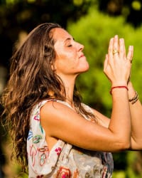 author with hands clasped in prayer