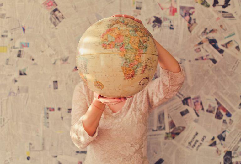 woman holding antique globe in front of face