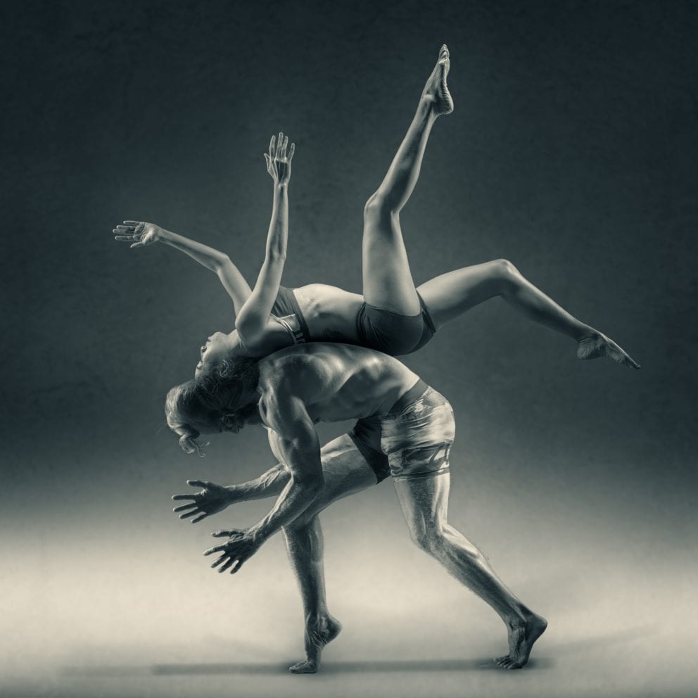 woman flipping over man yoga dance black and white