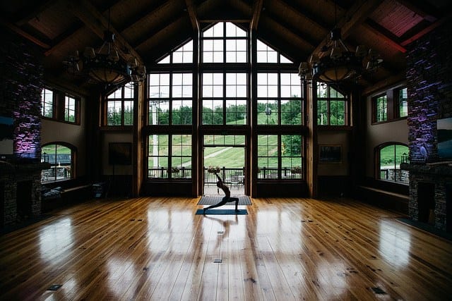 woman in high lunge in mountain lodge with large window