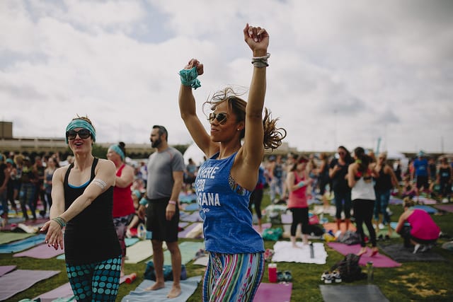 woman jumping dancing in field at yoga festival