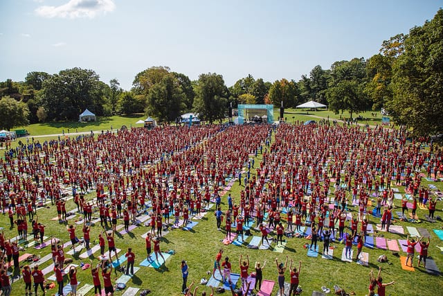 large crowd of people in field wearing red tshirts