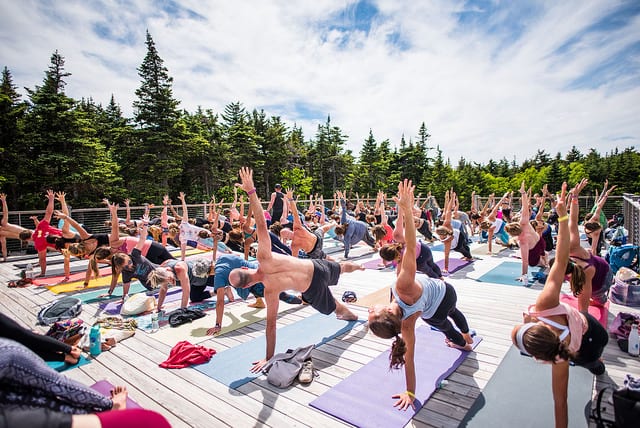 people practicing side plank pose on top of mountain