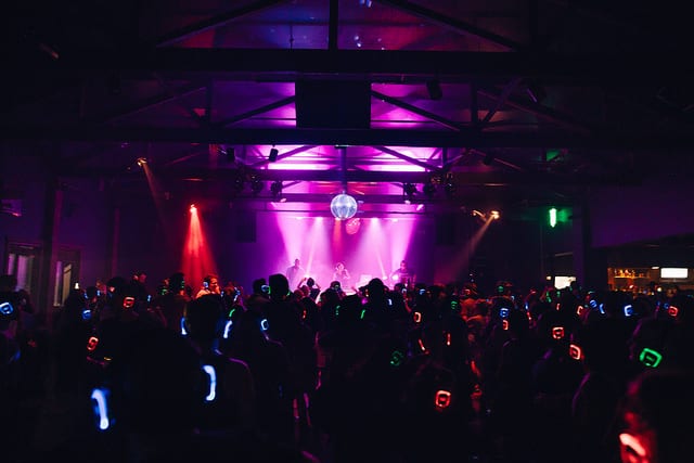 silent disco with purple lights against stage with disco ball