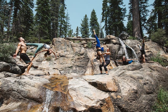 people doing acro on rock with creek