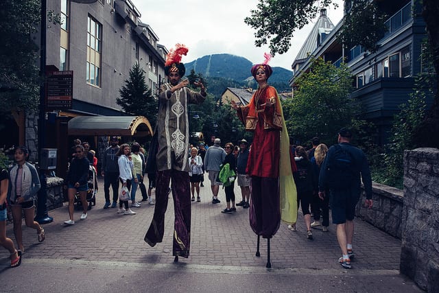 marching band on stilts walking through mountain town