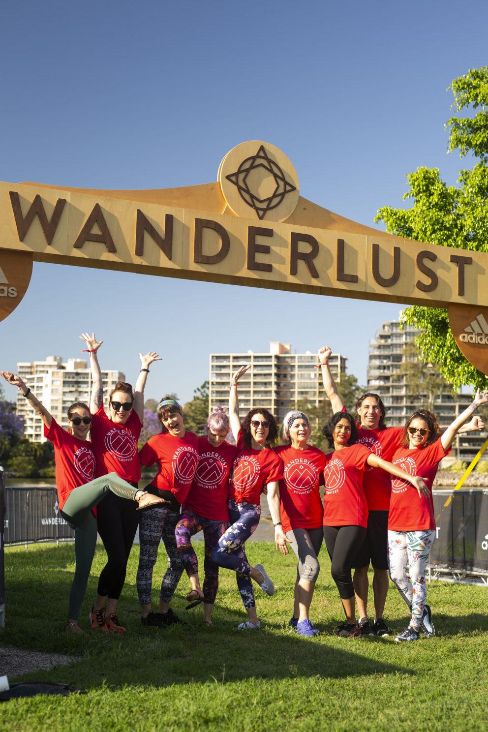 group of people in red shirts under Wanderlust arch