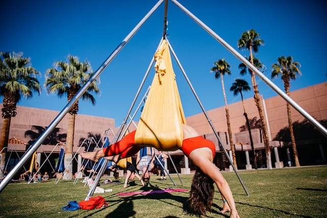 woman practicing aerial yoga in field doing backbend