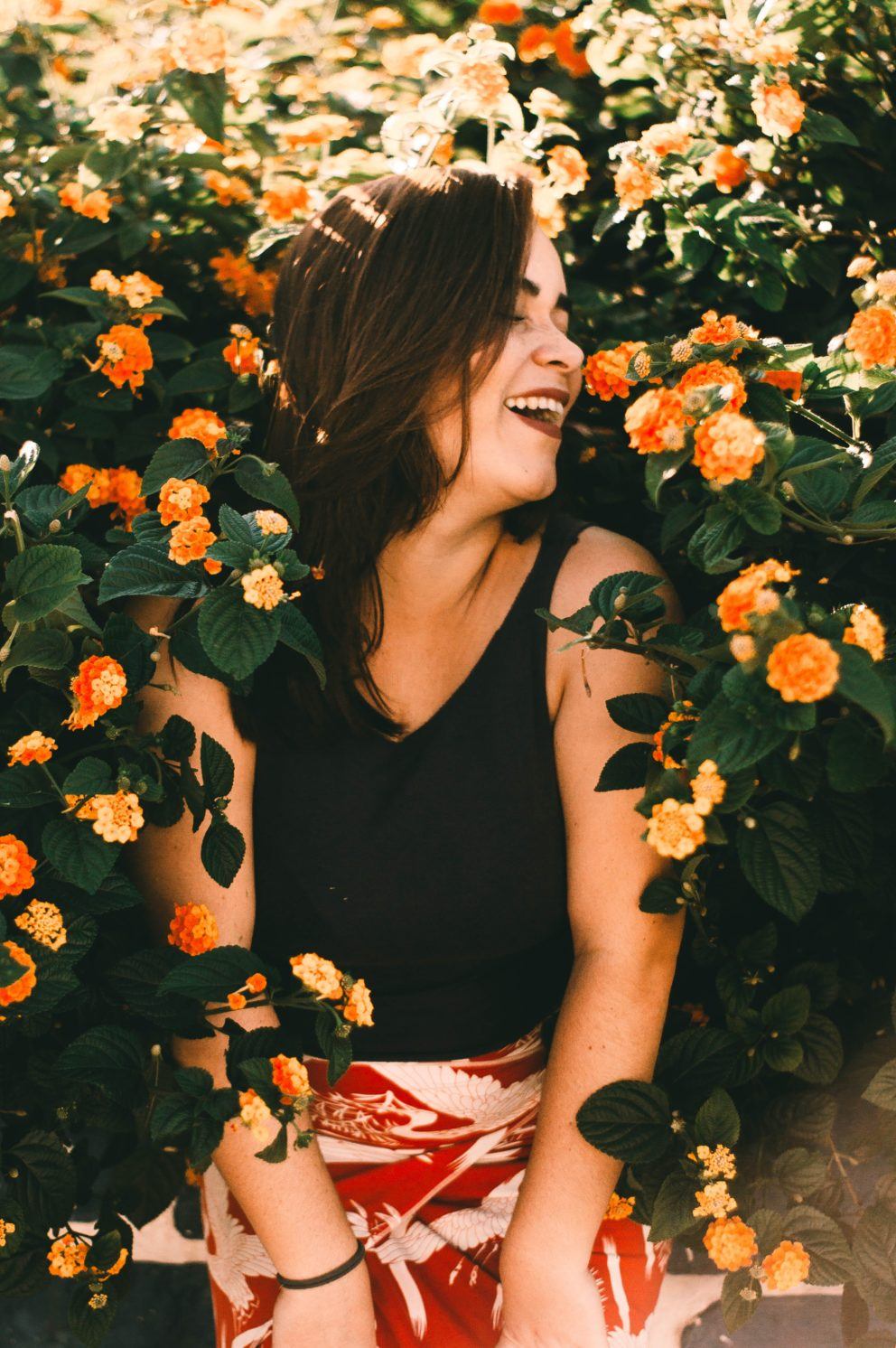 woman laughing in field of flowers