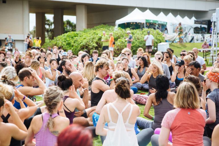 large group of yogis with hands in Anjali mudra