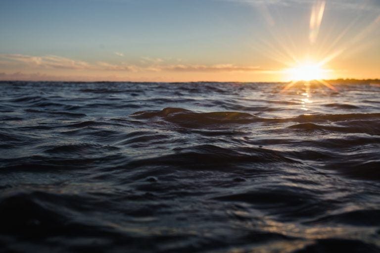 close up of water with sunset in background