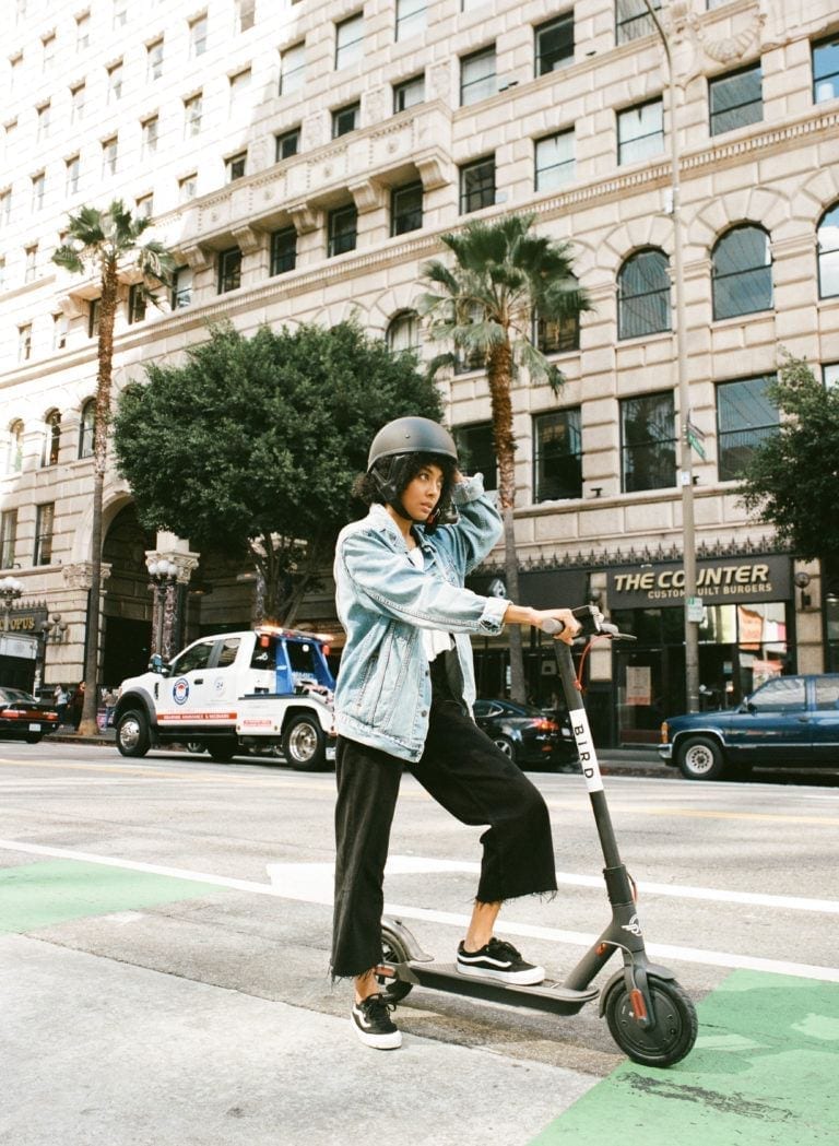 woman on scooter riding through city