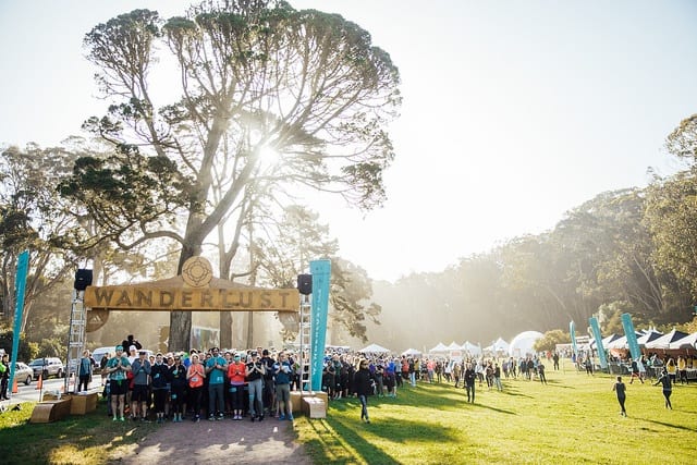 running arch with line of people in city park