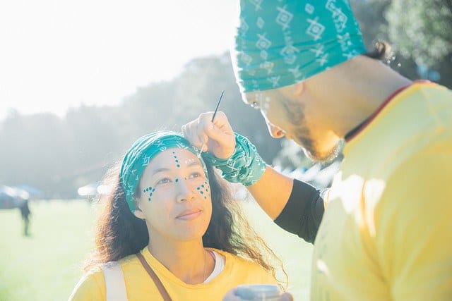 woman getting facepaint at festival