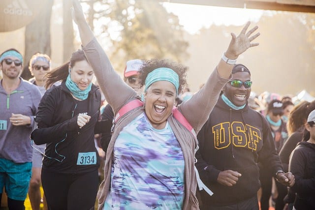 woman with arms raised excited for running race