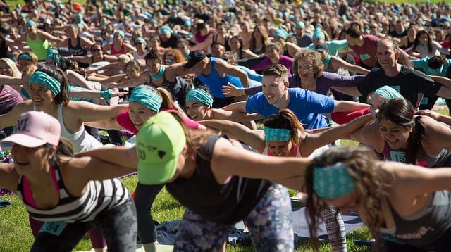 Largescale yoga class people holding each other's backs