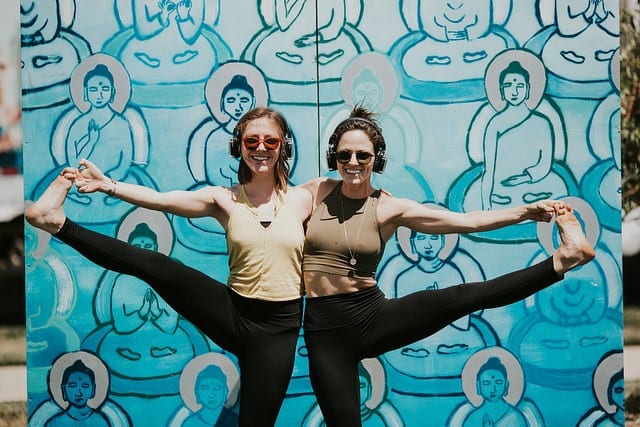 two girls in Denver in front of buddha wall