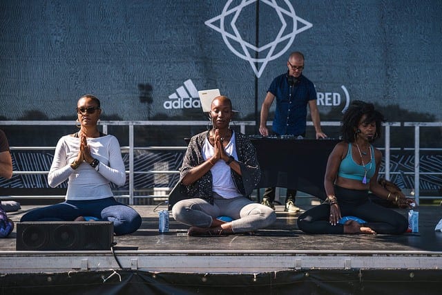 3 teachers sitting on stage at yoga festival