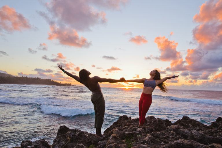 people doing yoga at the shoreline