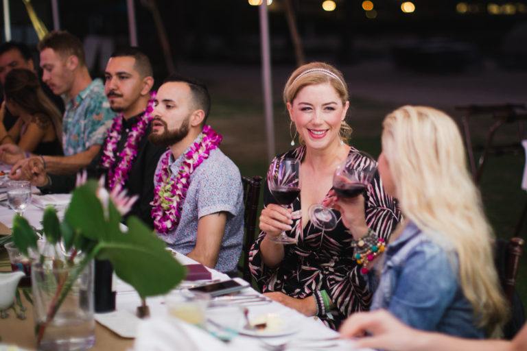 people drinking wine wearing leis