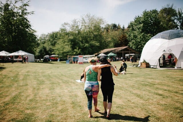 women walking arm in arm at festival grounds