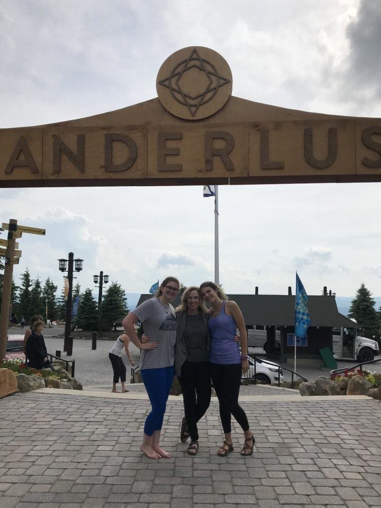 woman with two granddaughters under Wanderlust arch