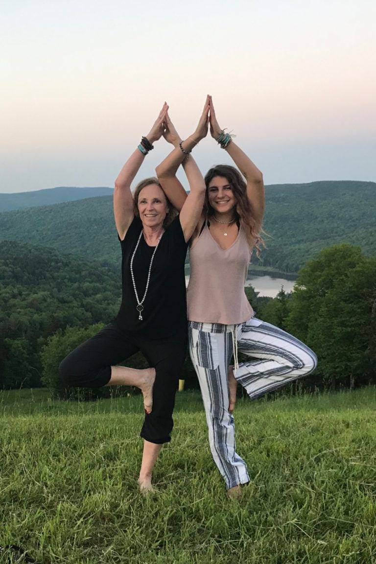 woman and granddaughter in tree pose at top of mountain