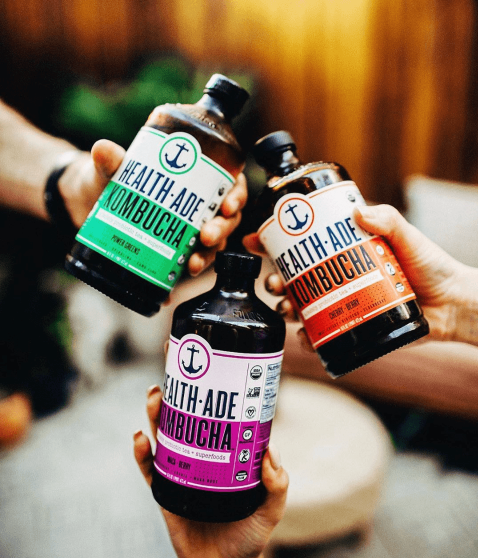 kombucha bottles giving cheers